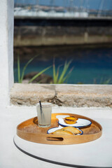 Cascais, Portugal: Refreshing lemonade and delicious portuguese pastel de nata served on a wooden tray, with a scenic waterfront view in the background, creating a serene dining experience