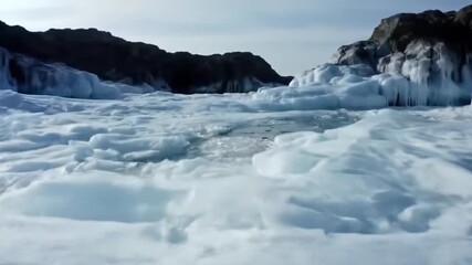 Icy shorelines with transparent sheets of ice cracked to reveal bubble formations near rocks - Powered by Adobe