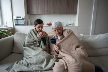 Sick elderly shivering husband and wife under blankets feel bad and sick, fatigue and low energy....