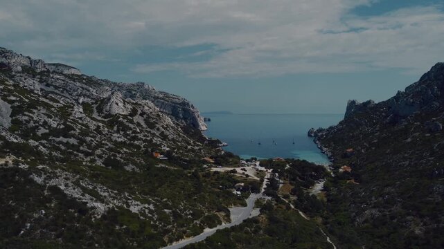 View of a stunning calanque in southern France, featuring crystal-clear turquoise water, dramatic white limestone cliffs, and a picturesque Mediterranean bay.