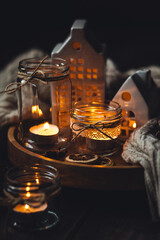 Creative handmade christmas home decor decorations: simple glass jars with aroma candles decorated with a ribbon, cinnamon, anise, dry orange. Cozy atmospheric composition for holiday mood creation