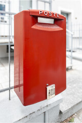 Red Italian Poste mail collection box on railing