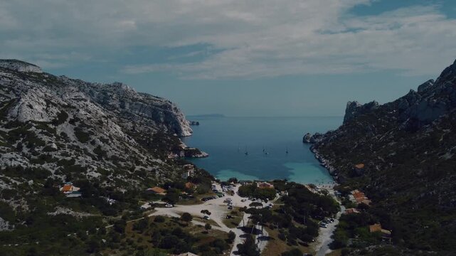 View of a stunning calanque in southern France, featuring crystal-clear turquoise water, dramatic white limestone cliffs, and a picturesque Mediterranean bay.