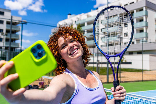 Tennis player taking selfie after training on court