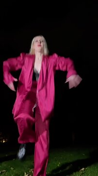 Young woman dancing waacking in a park at night