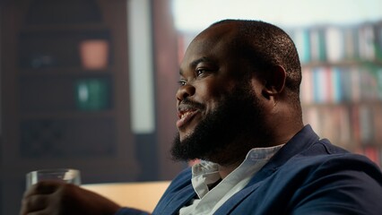 Black gentleman serving a glass of scotch whiskey at the private social club, meeting with the...