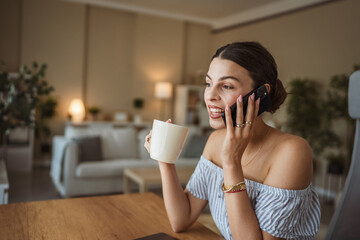 happy woman enjoy while drink coffee and talk on mobile phone at home