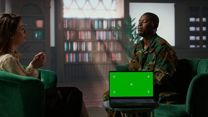 Military personnel discuss with a therapist next to chroma key screen, suffering from PTSD after...