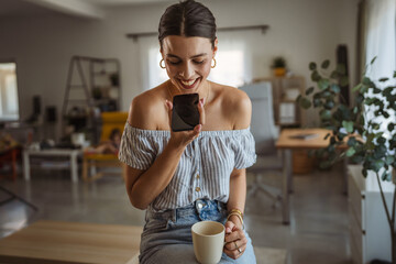woman enjoy while drink coffee and use mobile phone for audio recognition