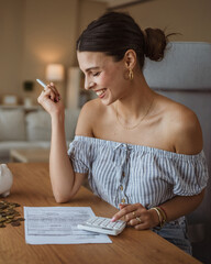 adult woman use calculate machine and review home bills and savings