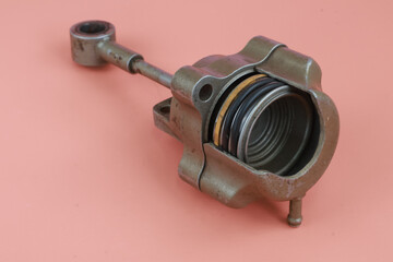 Turbocharger Actuator also known as a wastegate actuator with body cover partialy split and showing the inside part. isolated on brown background.