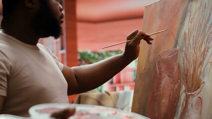 Confident painter mixing different watercolors on palette to create the perfect shade and apply on...