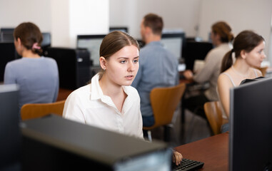 Young woman using computer for work in office with colleagues