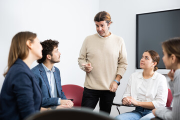 Experienced male teacher giving lecture to group of student