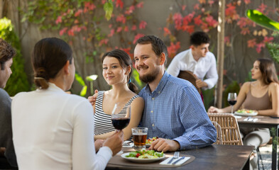 Meeting of two married couples in a cozy open-air restaurant