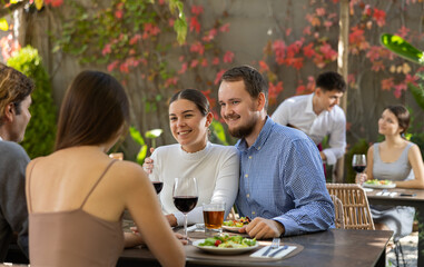 Meeting of two married couples in a cozy open-air restaurant