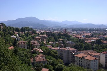 Fototapeta premium Panoramic green cityscape of Bergamo, Lombardy, Italy with hill and Alps view, Upper Town (Città Alta)