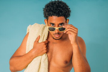 isolated portrait of man looking with sunglasses in swimsuit with beach or pool towel