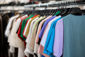 Obraz premium Variety of women's t-shirts and blouses hang on rack in clothing store