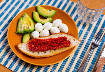 Avocado slices served with boiled eggs and toast for breakfast