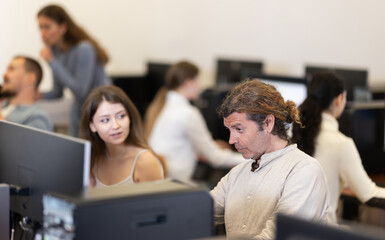 Man student of computer courses types on keyboard, performs work, educational practical task. Pupil performs educational tasks using computer.