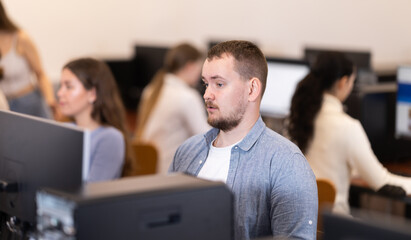 Young man working on computer with team in coworking space