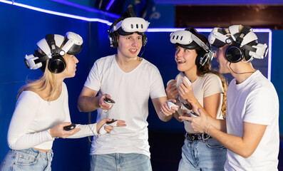 Joyful friends after playing together in VR helmets, they actively share emotions and impressions...