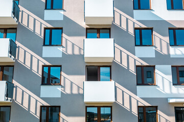 Symmetrical apartment building facade with balconies and long shadows