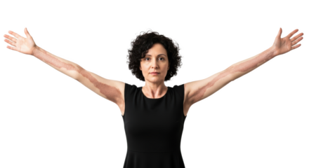 A woman with curly hair in a black dress standing with her arms outstretched against a black background