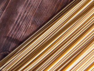 Dry Bucatini Pasta Arranged Diagonally on a Rustic Dark Wood Table