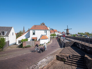 bicycles and street with old houses and windmill in dutch town of wijk bij duurstede on sunny day in spring