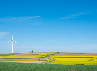 countryside landscape in luxemburg with wind turbine under blue sky in spring