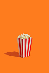 Striped box with popcorn on an orange background