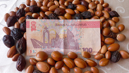 Moroccan 100 dirham banknote over Argan seeds