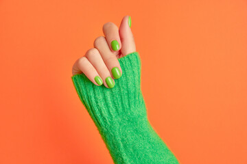 Beautiful womans hands with spring autumn nail design on orange background. Manicure, pedicure beauty salon concept