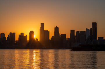 Obraz premium Silhouette View Of the Seattle Skyline During a Dramatic Sunrise. A view from West Seattle looking across Elliott Bay toward the waterfront of the city of Seattle, Washington.