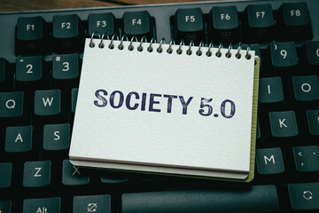 There is notebook with the word Society 5.0. It is as an eye-catching image.