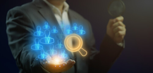 Recruitment icon, HR human resources solution concept. Management tool used to manage employee information in organization. Businessman with magnifying glass icons on virtual screen.