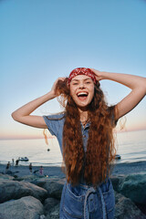 Lifestyle woman in modern boho-western denim street style laughing with long curly hair and red...