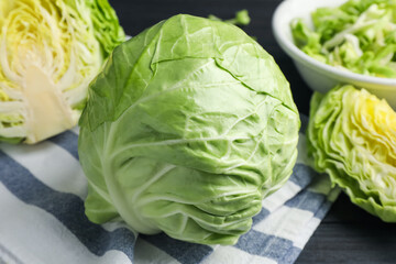 Fototapeta premium Fresh whole and cut cabbages on table, closeup