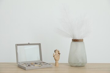 Jewelry box with many different accessories, mannequin hand and other decor on wooden table near...