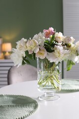 Beautiful table setting with vase of flowers in dining room