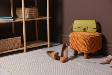 Stylish pouf with bag and shoes at home