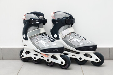 Pair of roller skates on floor near white wall