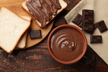Tasty chocolate butter, pieces and bread on wooden table, flat lay