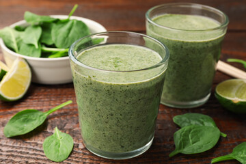 Tasty spinach smoothie and ingredients on wooden table, closeup