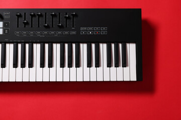 One portable MIDI keyboard on red background, top view