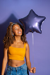 Young woman holding star shaped balloon expressing happiness and joy
