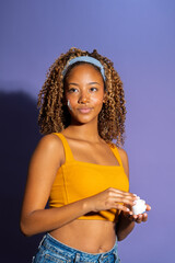 Young woman applying moisturizer on face for skincare routine