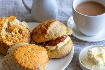 Traditional british scones with clotted cream and apricot jam for tea time